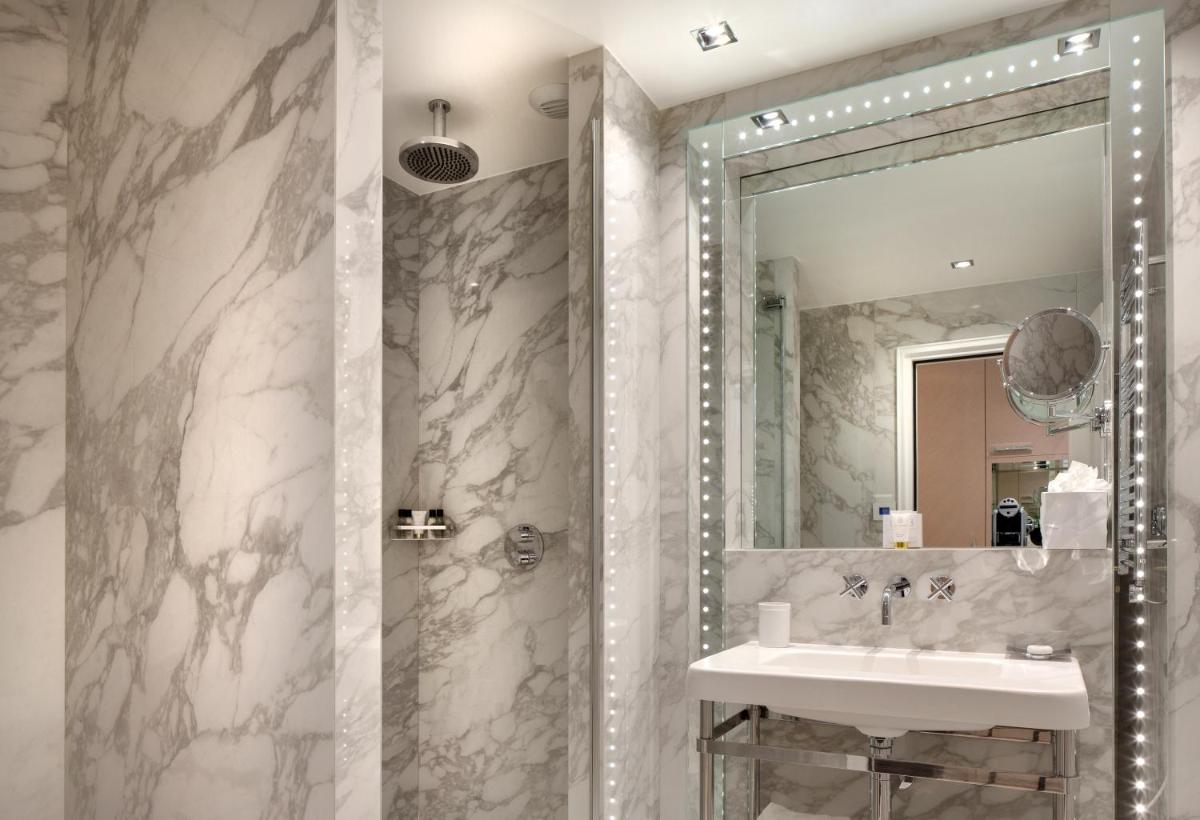 une salle de bain avec un lavabo et un miroir dans l'établissement Hotel Bowmann, à Paris
