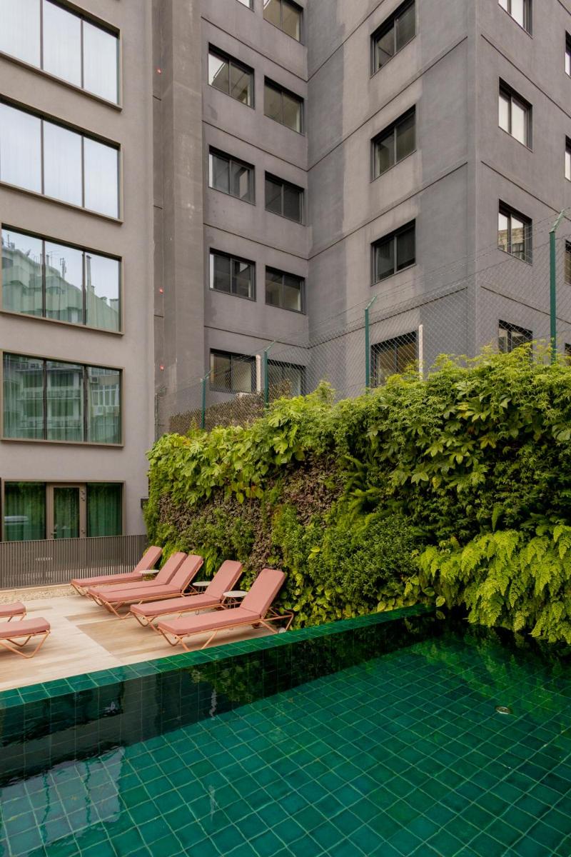 uma fila de espreguiçadeiras ao lado de um edifício em LUSTER Hotel em Lisboa