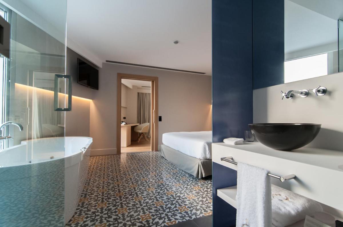 baño con bañera y lavabo y baño con cama en Hotel Sorli Emocions, en Vilassar de Dalt