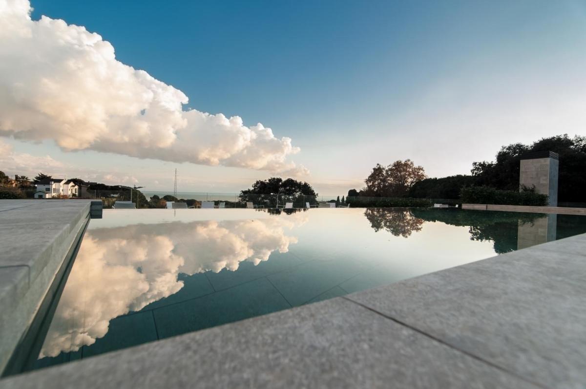 un reflejo de nubes en un charco de agua en Hotel Sorli Emocions, en Vilassar de Dalt