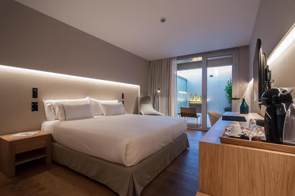 Un dormitorio con una cama grande y una ventana grande. en Hotel Sorli Emocions, en Vilassar de Dalt