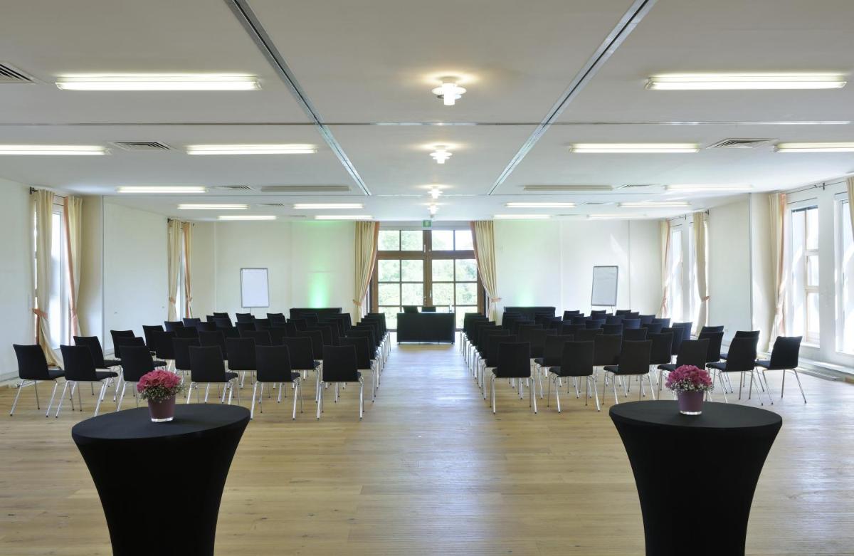 Zimmer mit schwarzen Stühlen, Tischen und Blumen in der Unterkunft Hotel Gut Ising in Chieming + 37 Fotos