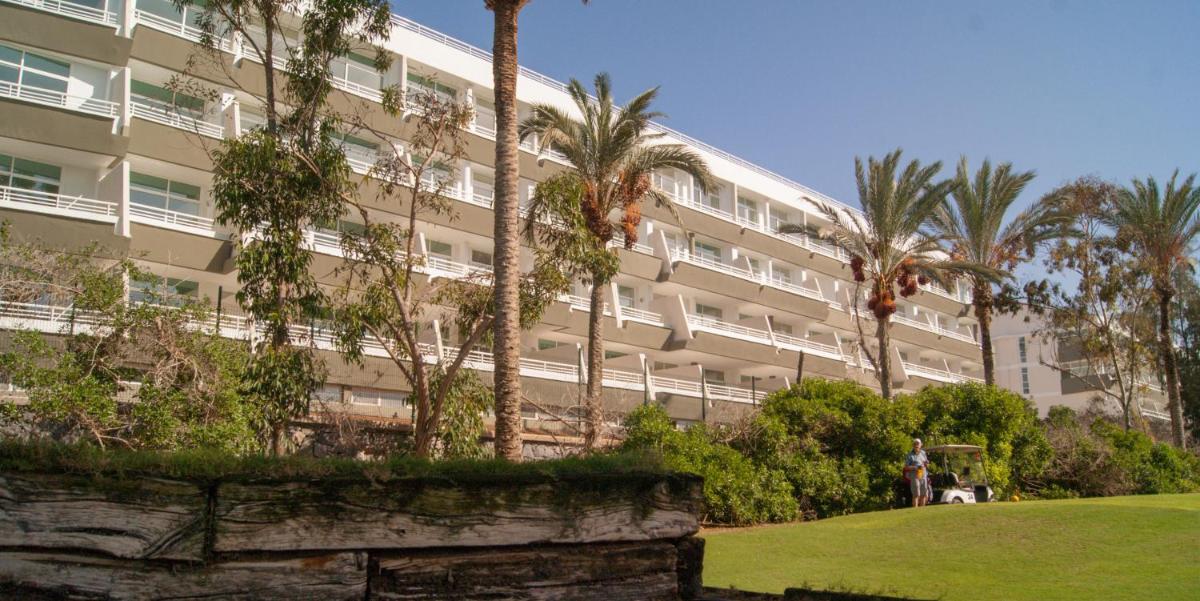 Un gran edificio con palmeras delante. en Gara Suites Golf & Spa, en Playa de las Américas