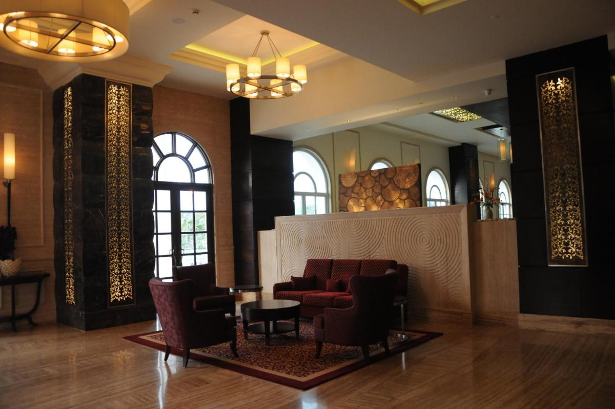 a lobby with a waiting room with chairs and a table at The Pllazio Hotel in Gurgaon