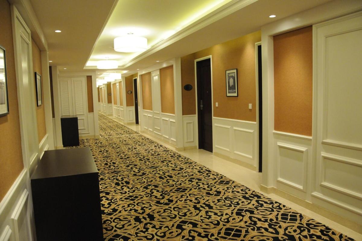 a hallway of a hotel with a patterned floor at The Pllazio Hotel in Gurgaon