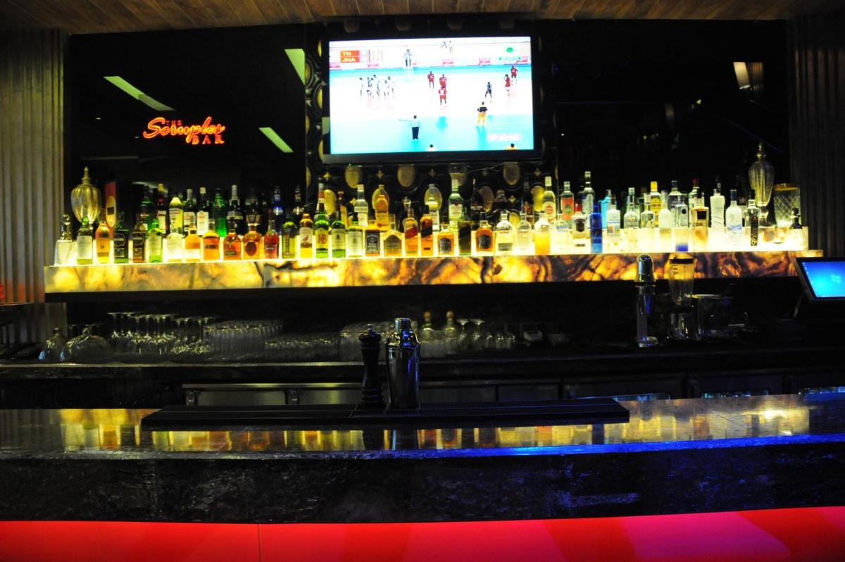 a bar with a bunch of bottles of alcohol at The Pllazio Hotel in Gurgaon