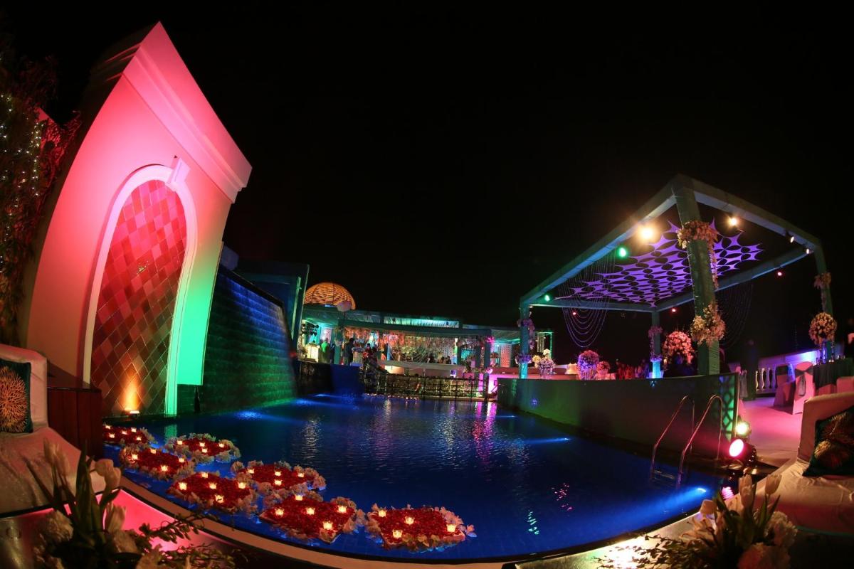 a resort with a swimming pool at night at The Pllazio Hotel in Gurgaon