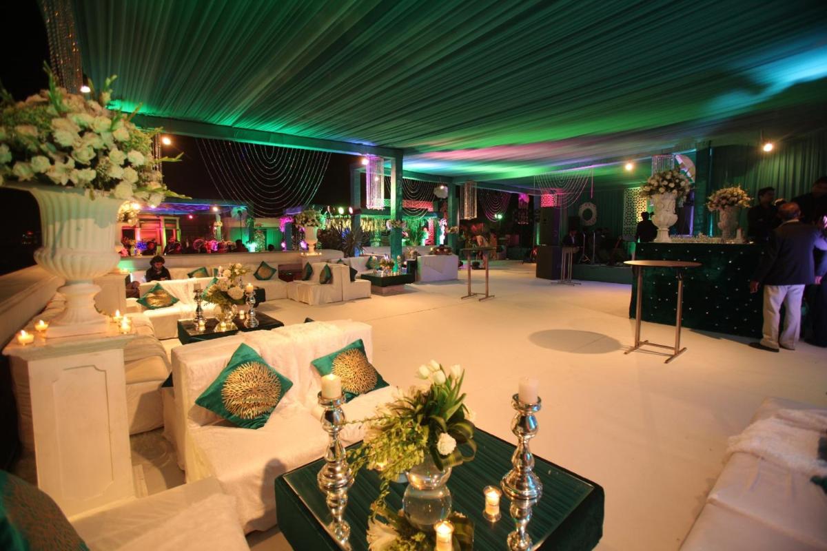 a room with white couches and a green ceiling at The Pllazio Hotel in Gurgaon +26 photos