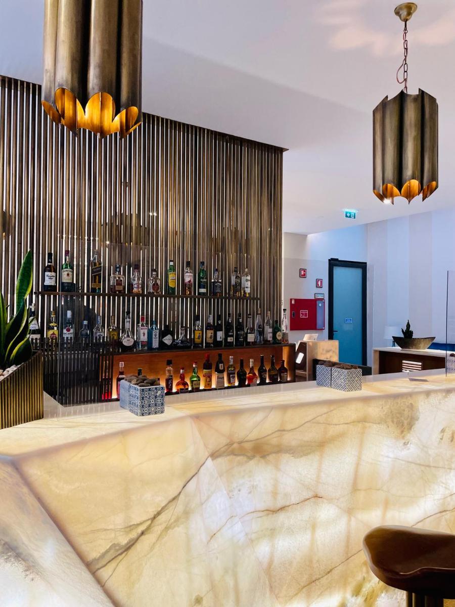 um átrio com um bar com garrafas de álcool em Castelo Hotel em Chaves
