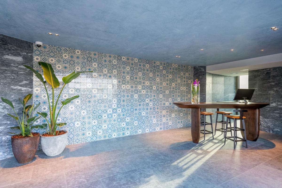 um quarto com uma mesa e um computador portátil na parede em W Residences Algarve em Albufeira um quarto com uma mesa e um computador portátil na parede em W Residences Algarve em Albufeira