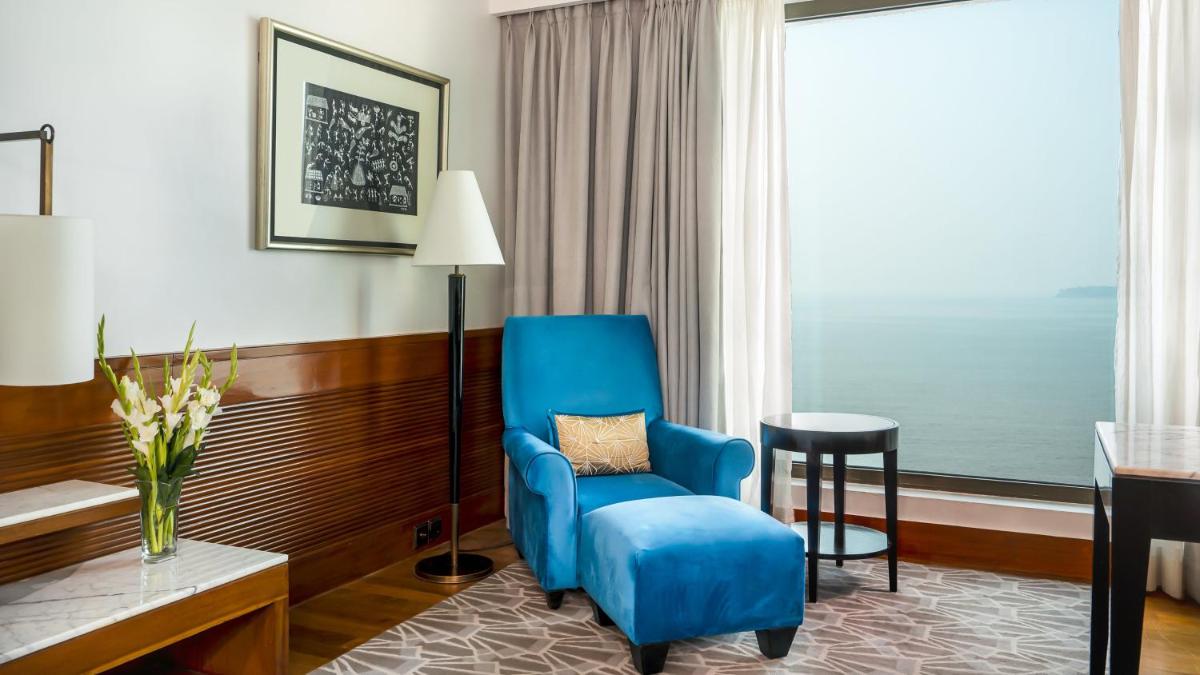 a room with a blue chair and a desk and a window at InterContinental Marine Drive Mumbai by IHG in Mumbai