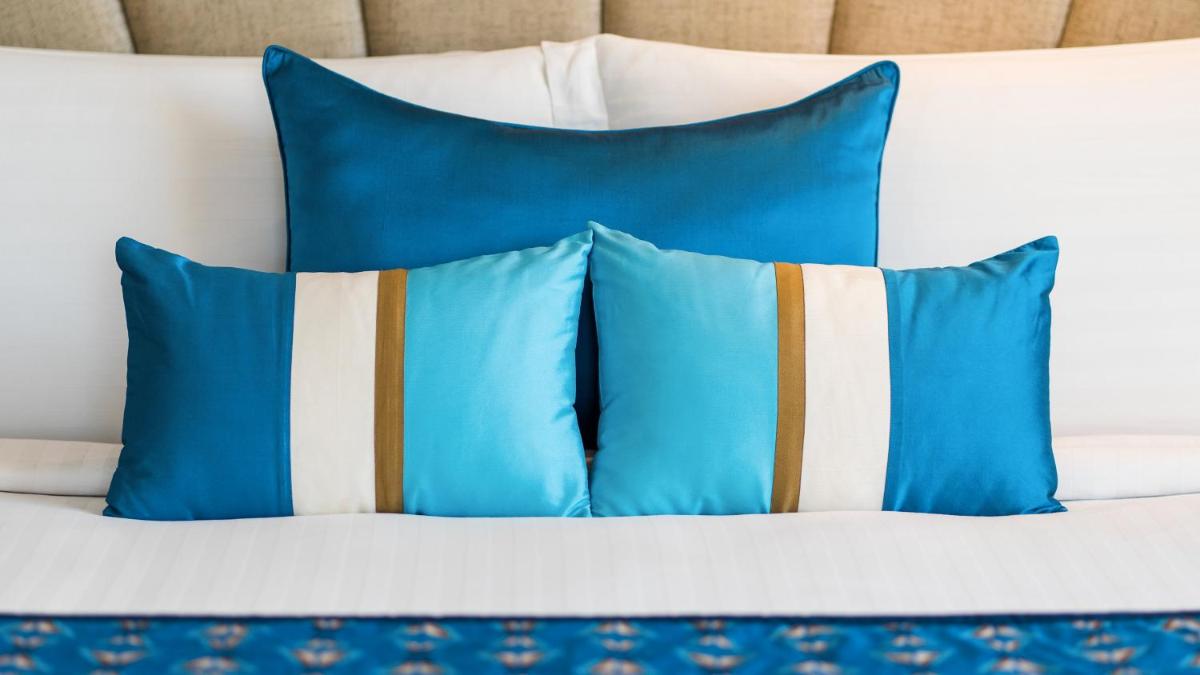 a group of blue pillows on a bed at InterContinental Marine Drive Mumbai by IHG in Mumbai