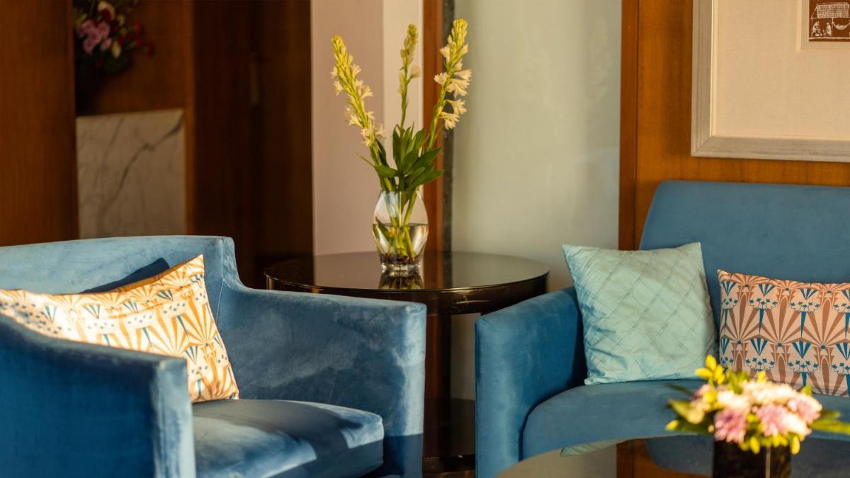 two blue chairs and a table with a vase of flowers at InterContinental Marine Drive Mumbai by IHG in Mumbai