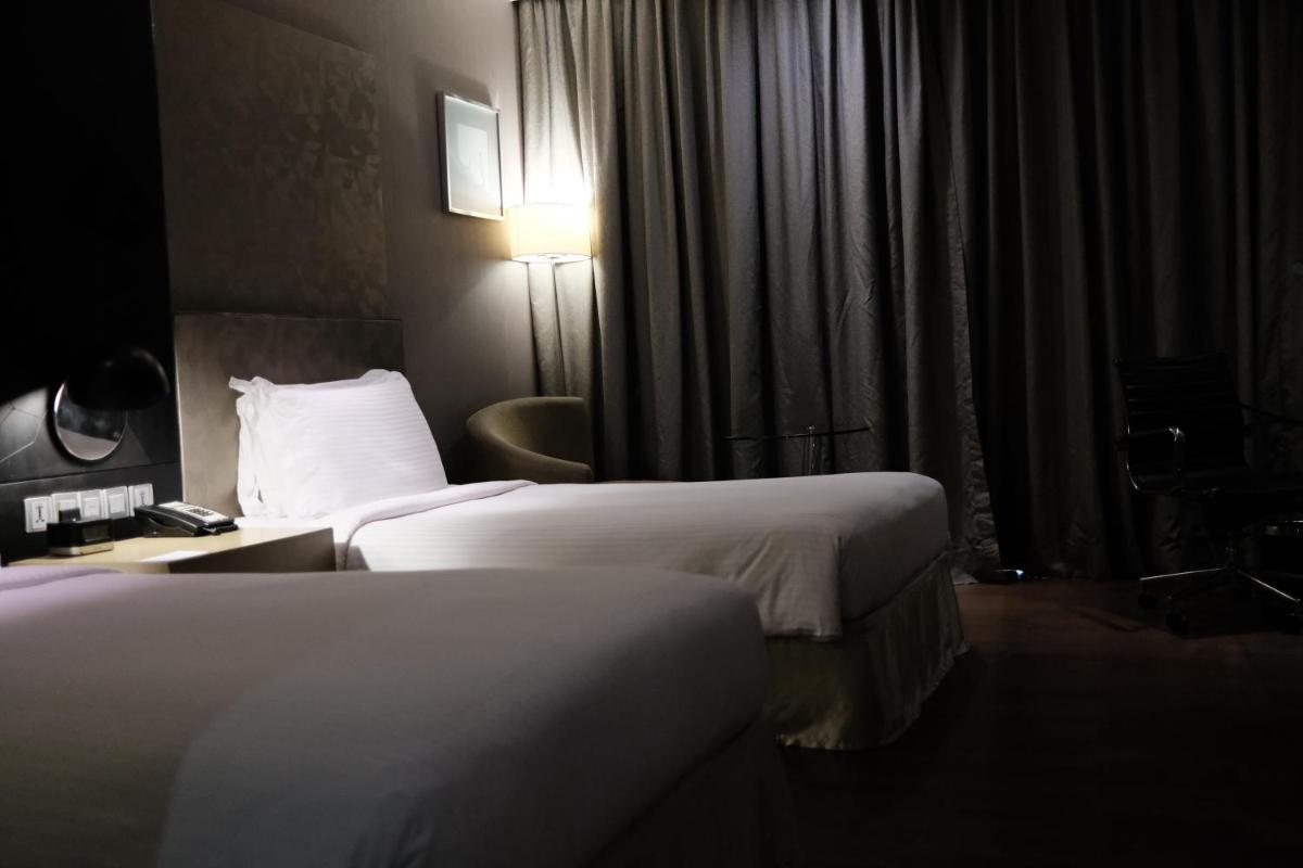 a hotel room with two beds and a desk with a lamp at Holiday Inn New Delhi Aerocity by IHG in New Delhi