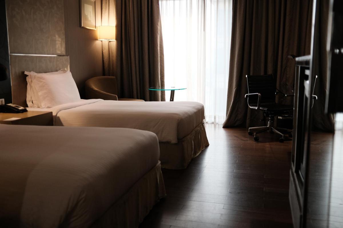 a hotel room with two beds and a window at Holiday Inn New Delhi Aerocity by IHG in New Delhi
