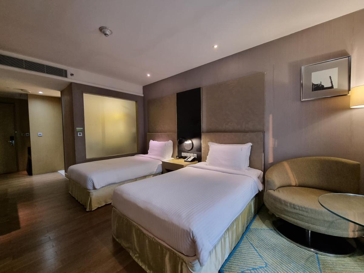 a hotel room with two beds and a chair at Holiday Inn New Delhi Aerocity by IHG in New Delhi