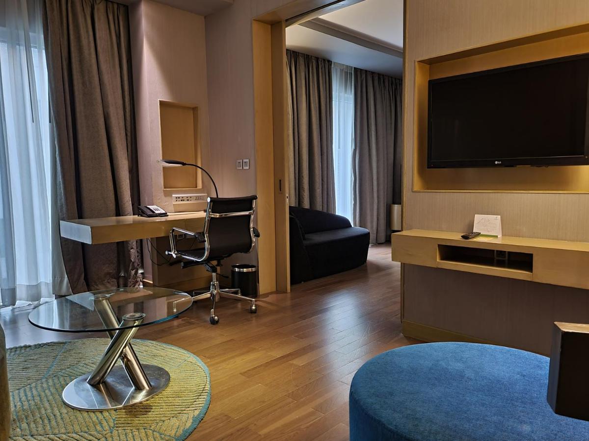 a hotel room with a television and a couch at Holiday Inn New Delhi Aerocity by IHG in New Delhi