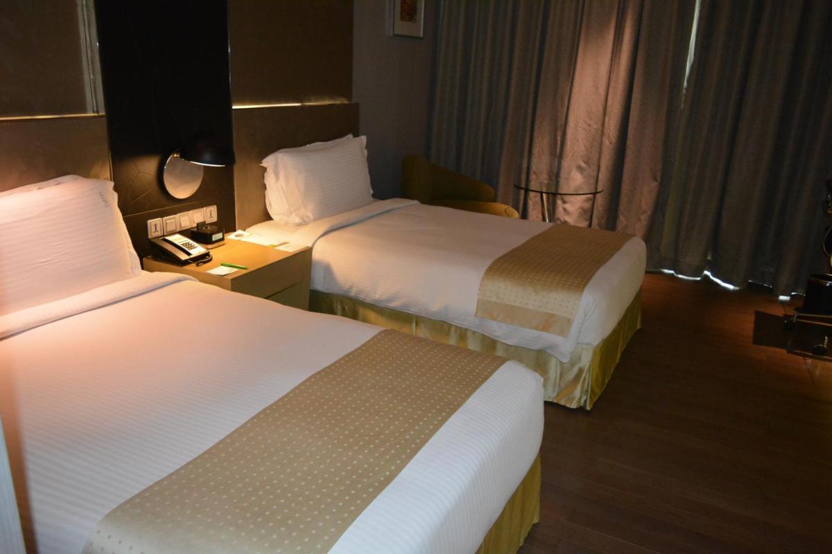 a hotel room with two beds and a telephone at Holiday Inn New Delhi Aerocity by IHG in New Delhi