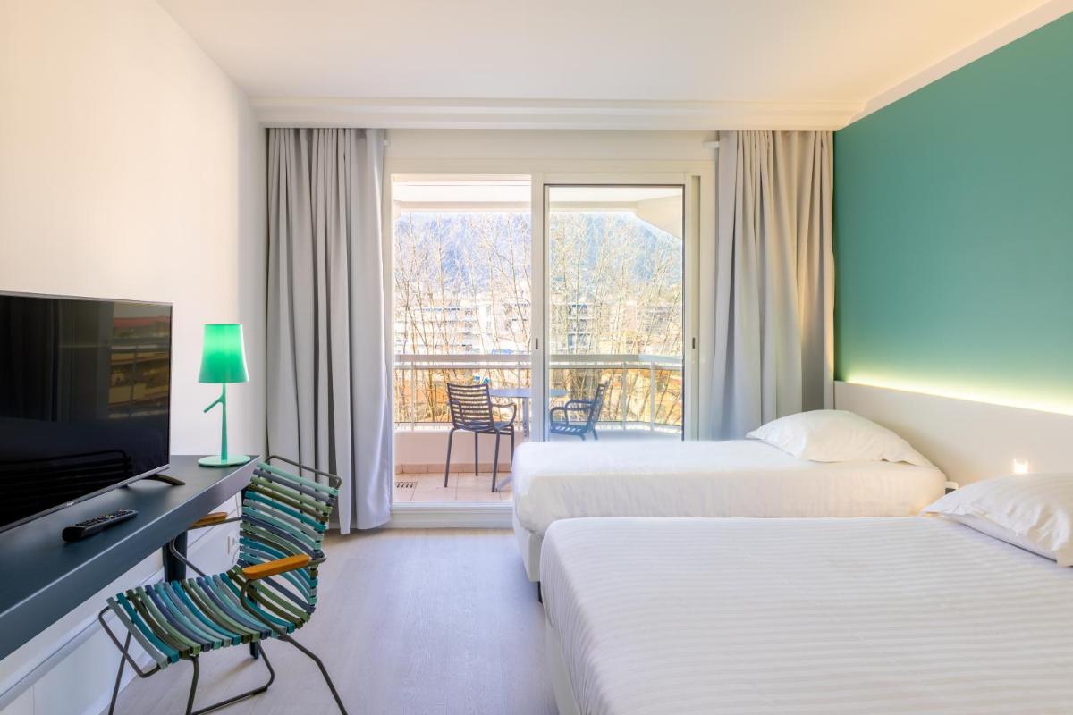 une chambre d'hôtel avec deux lits et un balcon dans l'établissement Hôtel Riva Art & Spa, à Menton 33 autres photos