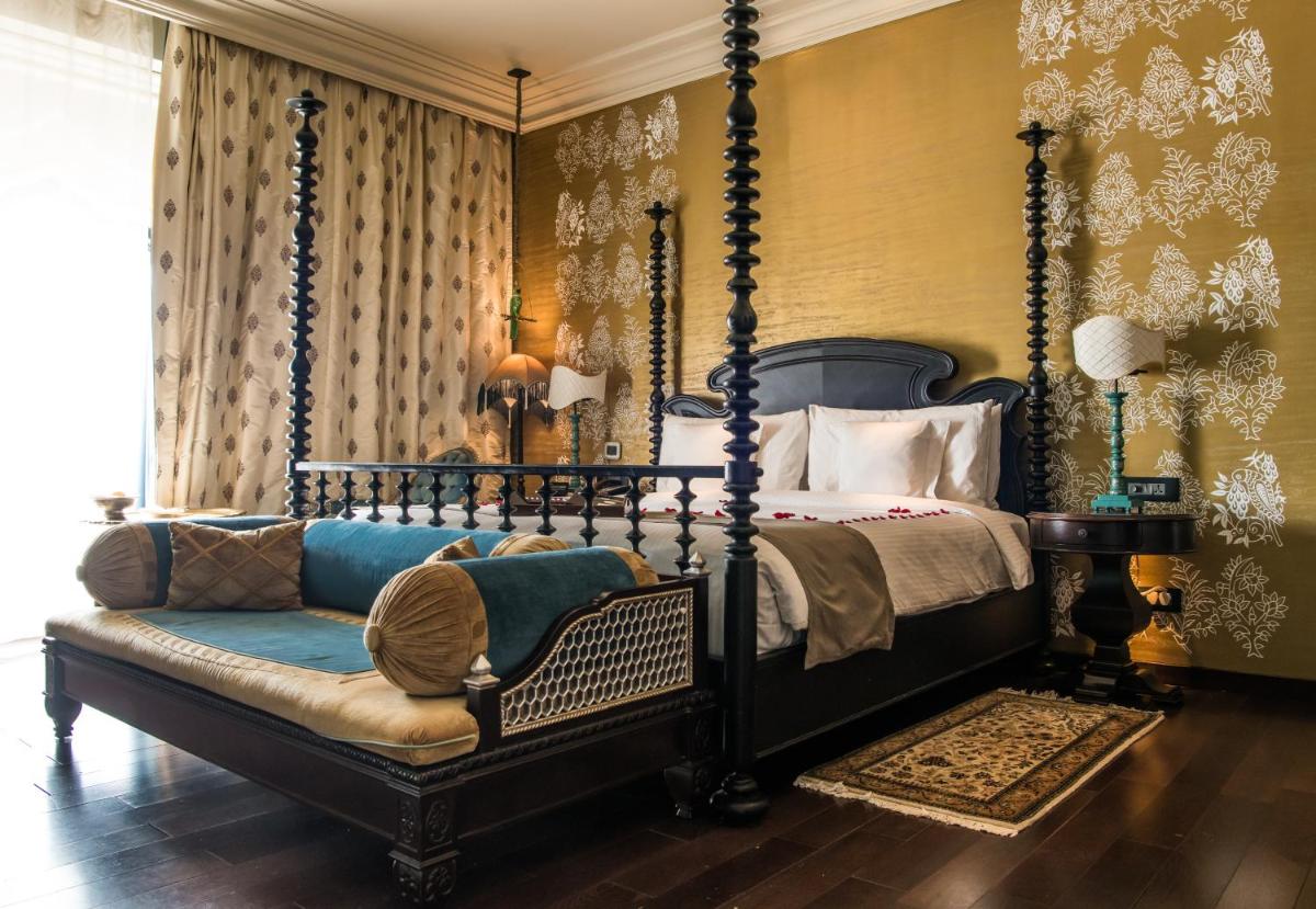 a bedroom with a canopy bed and a couch at Fairmont Jaipur in Jaipur
