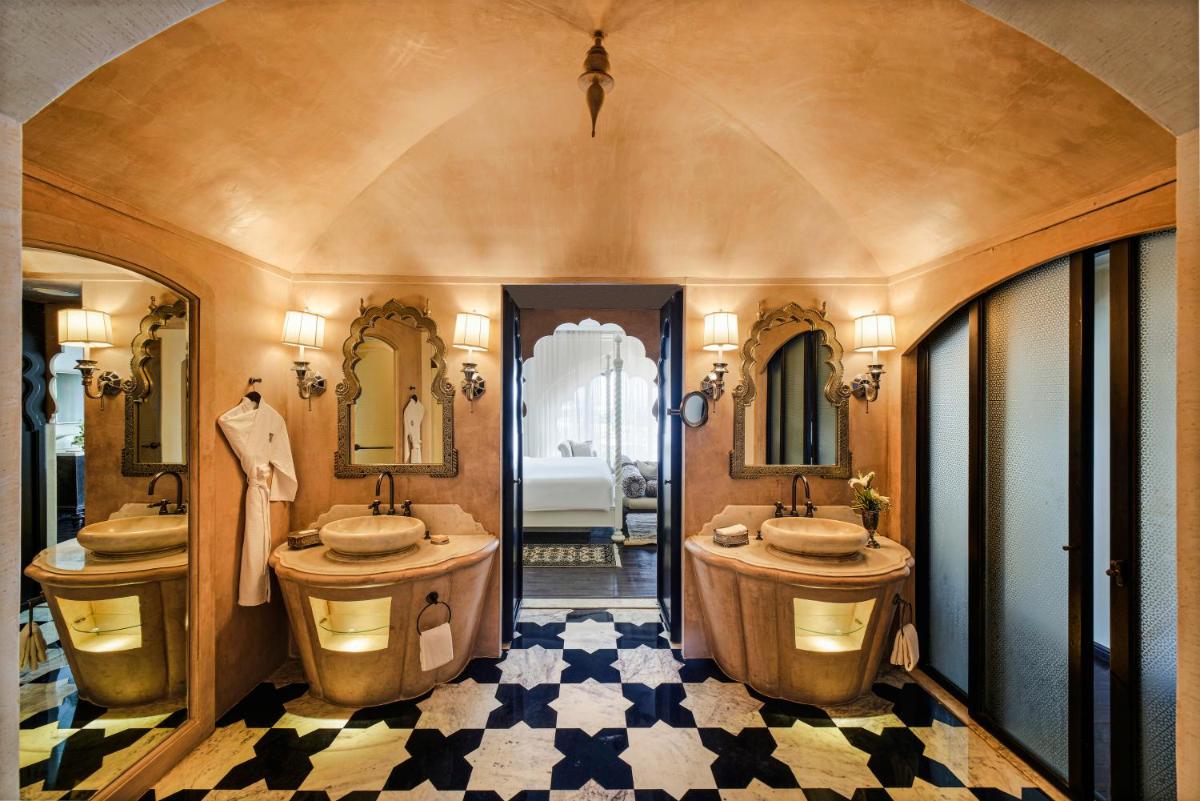a bathroom with two sinks and two mirrors at Fairmont Jaipur in Jaipur