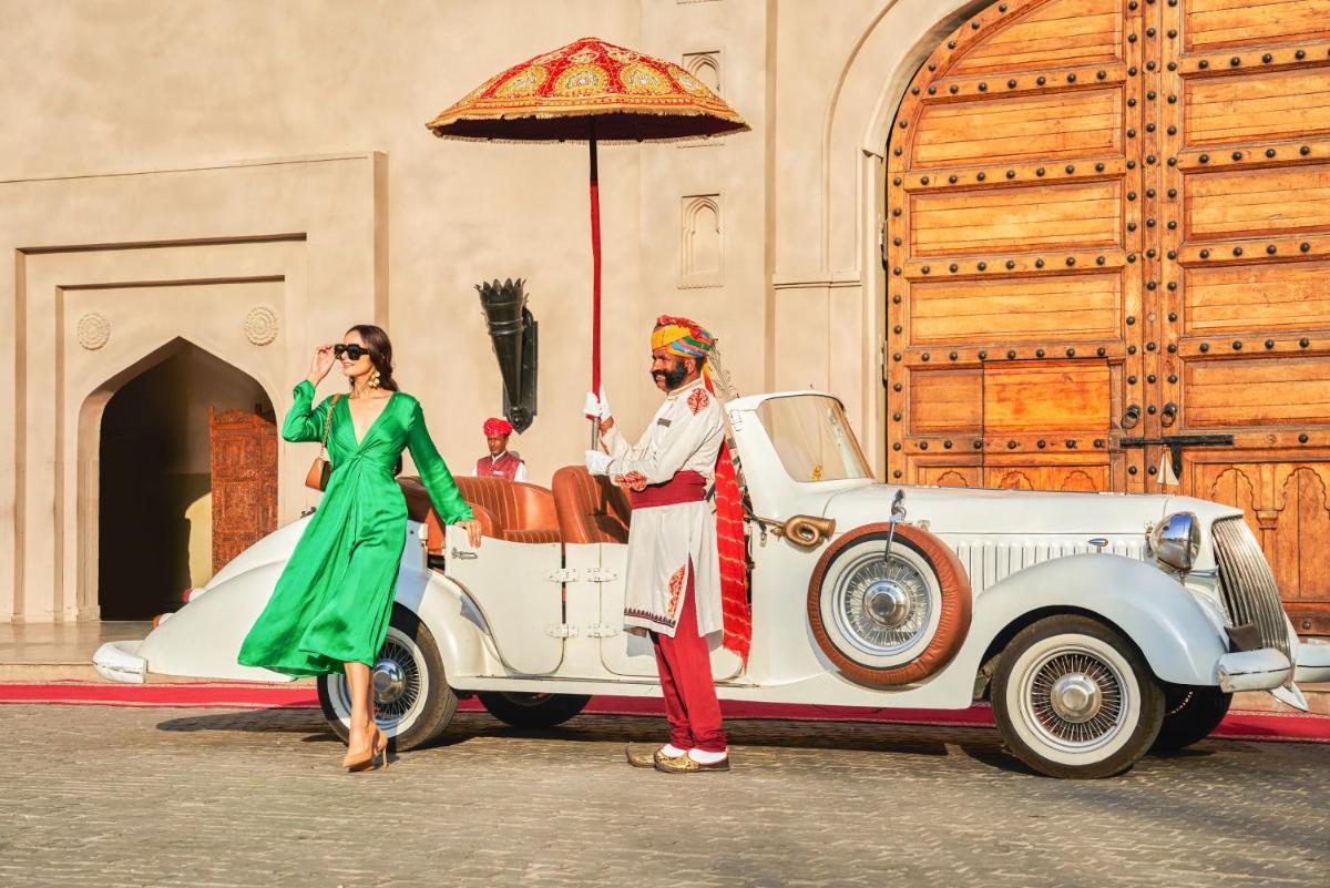 a man and a woman standing next to a white car at Fairmont Jaipur in Jaipur