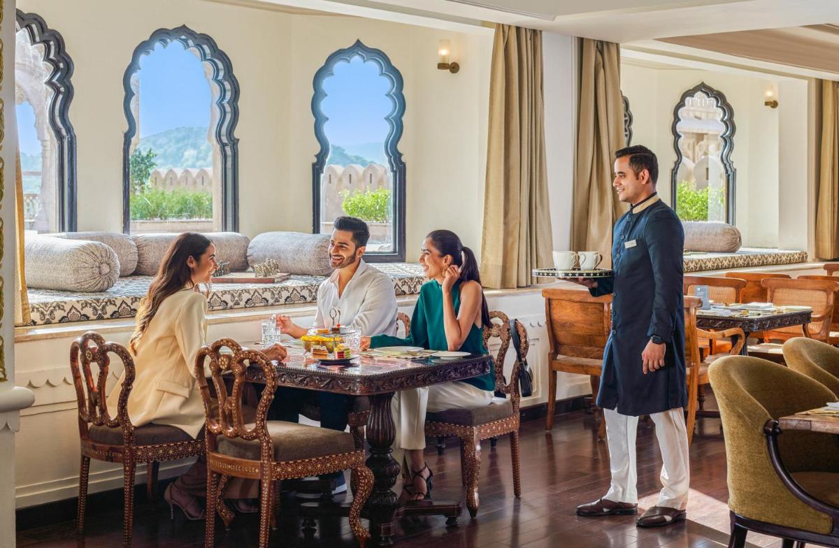 a group of people sitting at a table in a restaurant at Fairmont Jaipur in Jaipur