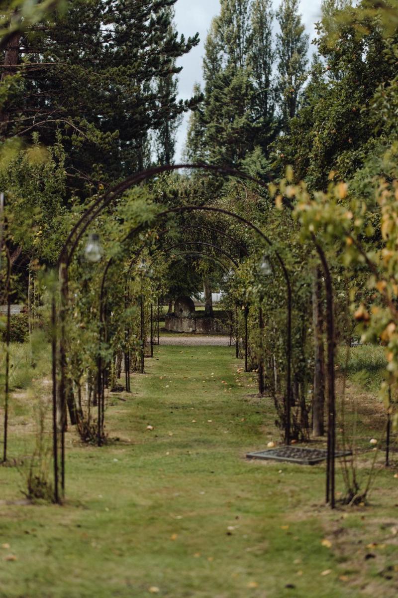 une arche avec des arbres au milieu d'un champ dans l'établissement Les Manoirs des Portes de Deauville - Small Luxury Hotel Of The World, à Deauville 69 autres photos