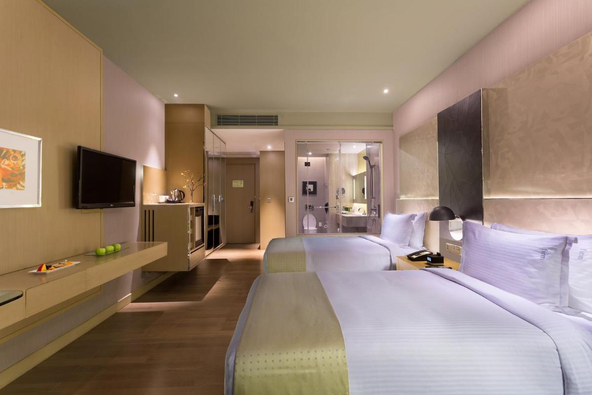 a hotel room with two beds and a television at Holiday Inn New Delhi Aerocity by IHG in New Delhi