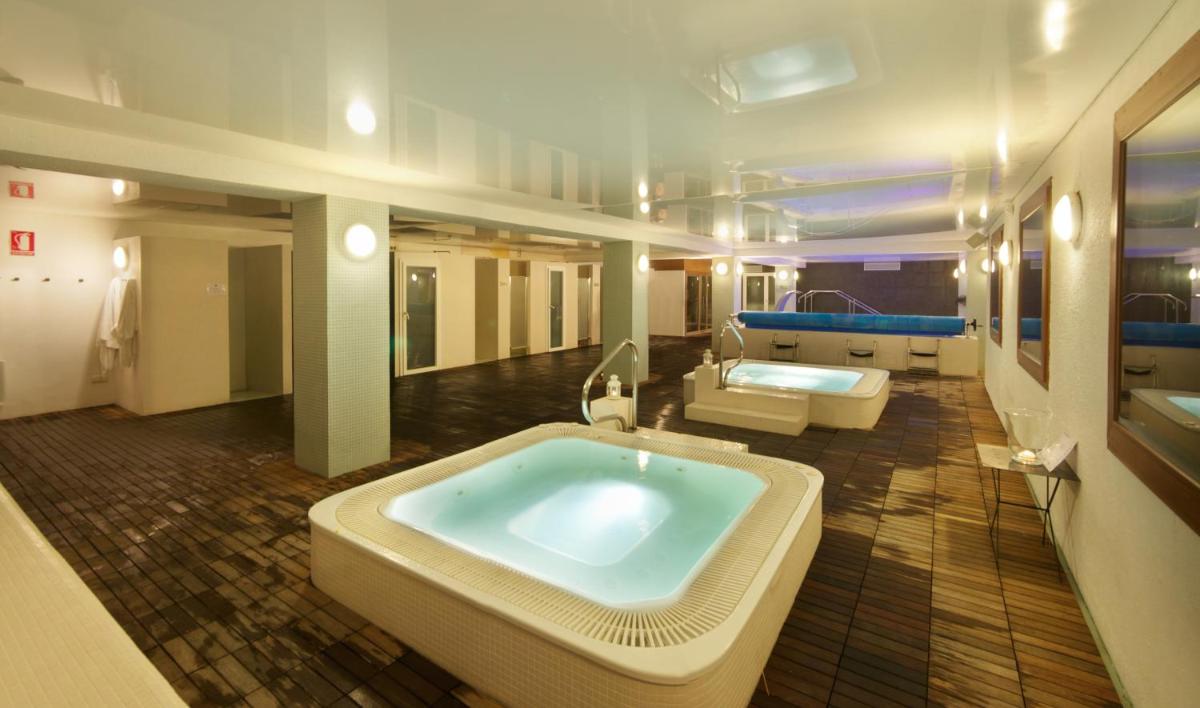 Un baño grande con una bañera grande en el medio. en Hotel Caldas, en Caldes de Boí