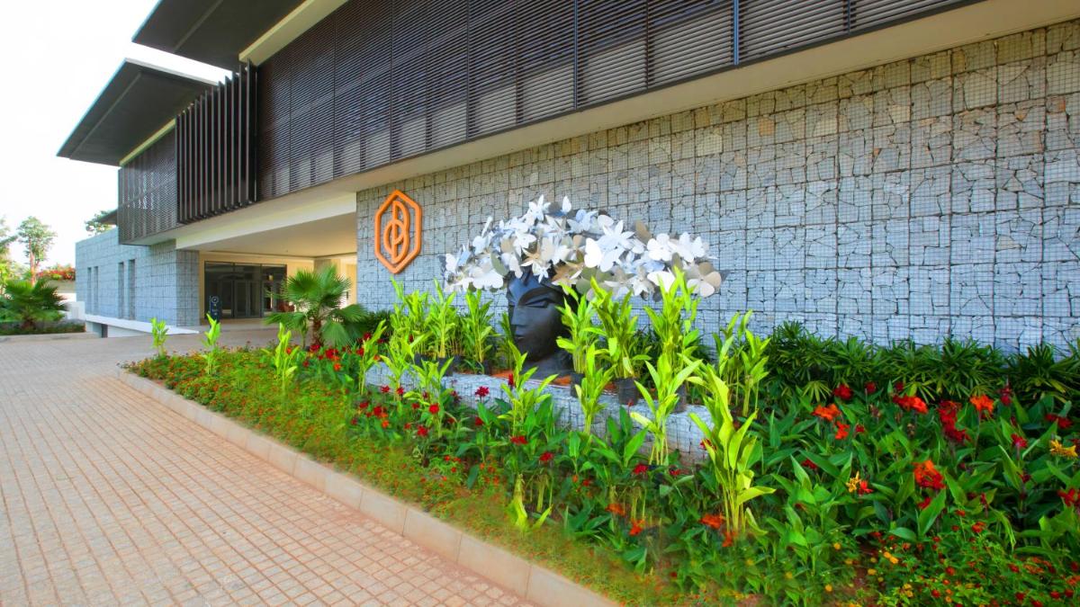 a garden of flowers in front of a building at BLVD Club - Near BENGALURU AIRPORT in Bengaluru