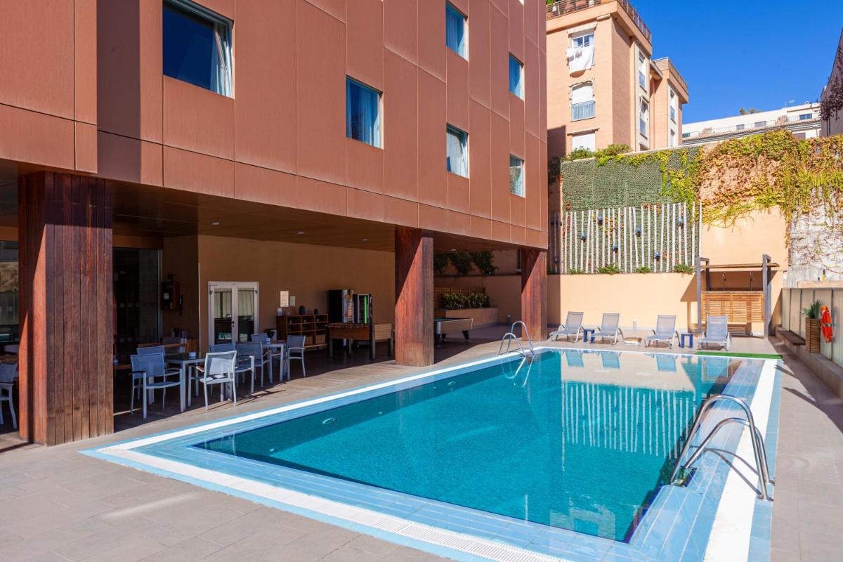 una piscina frente a un edificio en Hotel Macià Real De La Alhambra, en Granada