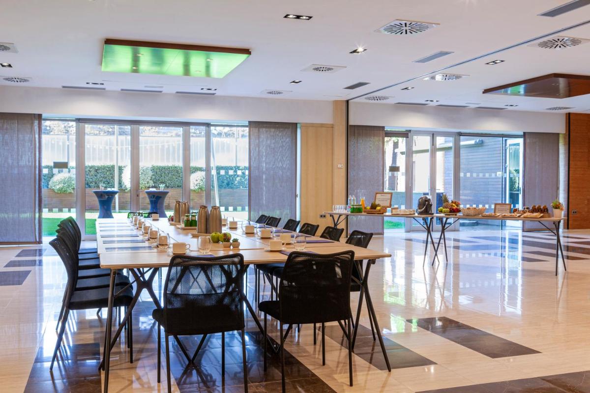 una sala de conferencias con una mesa larga y sillas en Hotel Macià Real De La Alhambra, en Granada