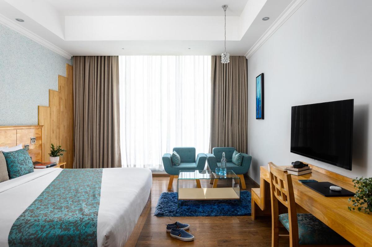 a hotel room with a bed and a flat screen tv at The Panoramic Getaway in Munnar