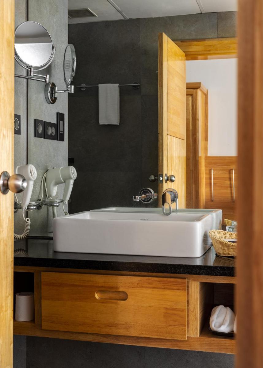 a bathroom with a white sink and a mirror at The Panoramic Getaway in Munnar