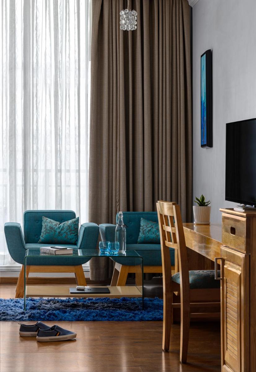 a living room with a table and chairs and a television at The Panoramic Getaway in Munnar