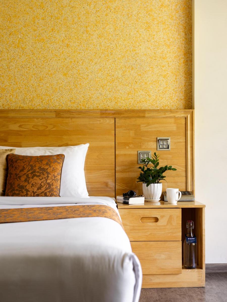 a bedroom with a bed with a wooden headboard at The Panoramic Getaway in Munnar