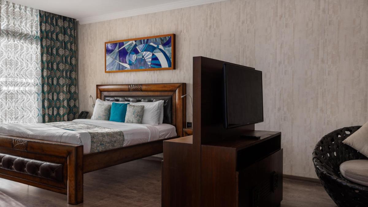 a bedroom with a bed and a flat screen tv at The Panoramic Getaway in Munnar