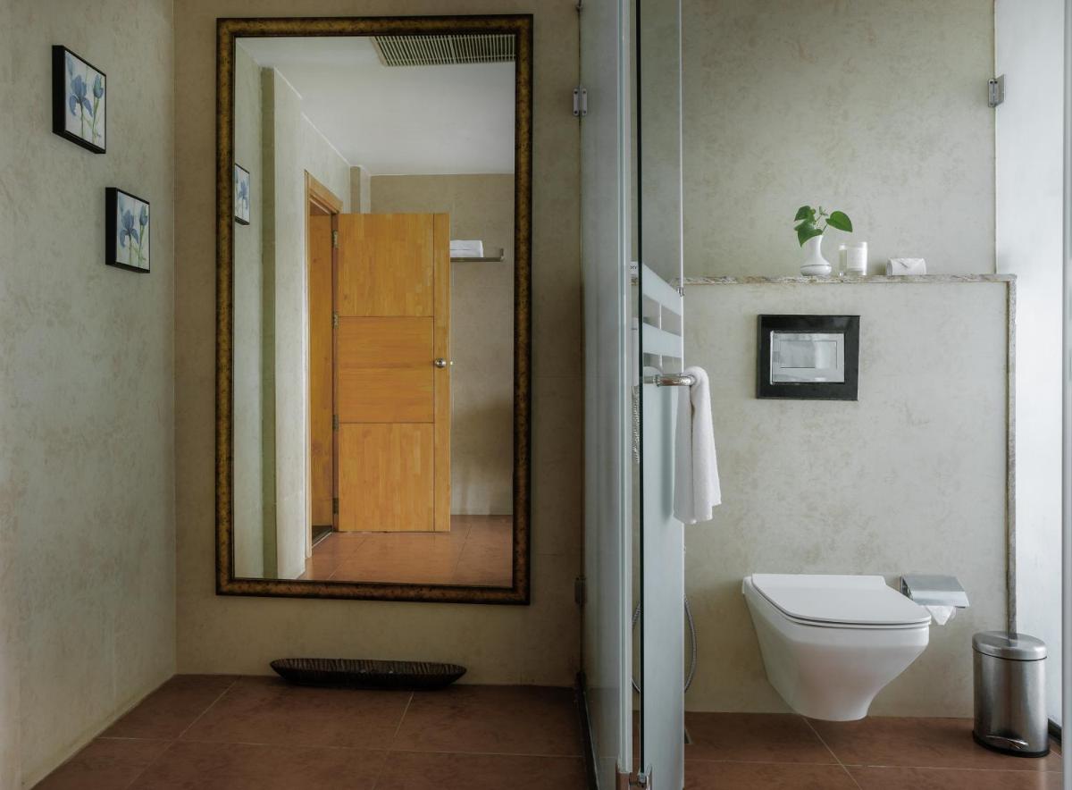 a bathroom with a toilet and a large mirror at The Panoramic Getaway in Munnar