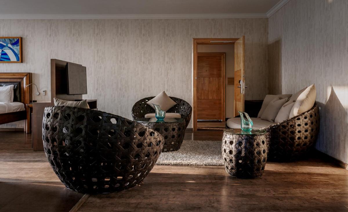 a living room with couches and chairs and a television at The Panoramic Getaway in Munnar