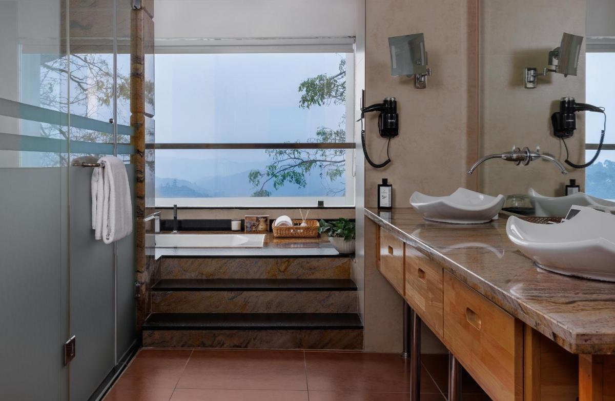 a bathroom with two sinks and a large window at The Panoramic Getaway in Munnar