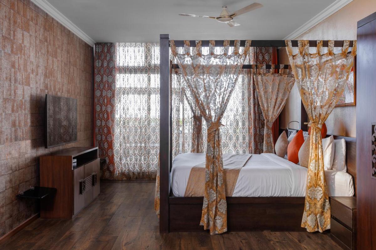 a bedroom with a canopy bed with curtains at The Panoramic Getaway in Munnar