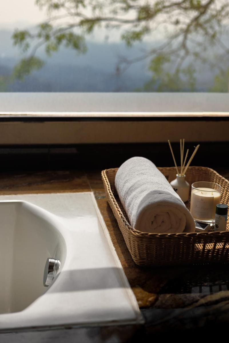 a bathroom sink with a towel in a basket next to a window at The Panoramic Getaway in Munnar
