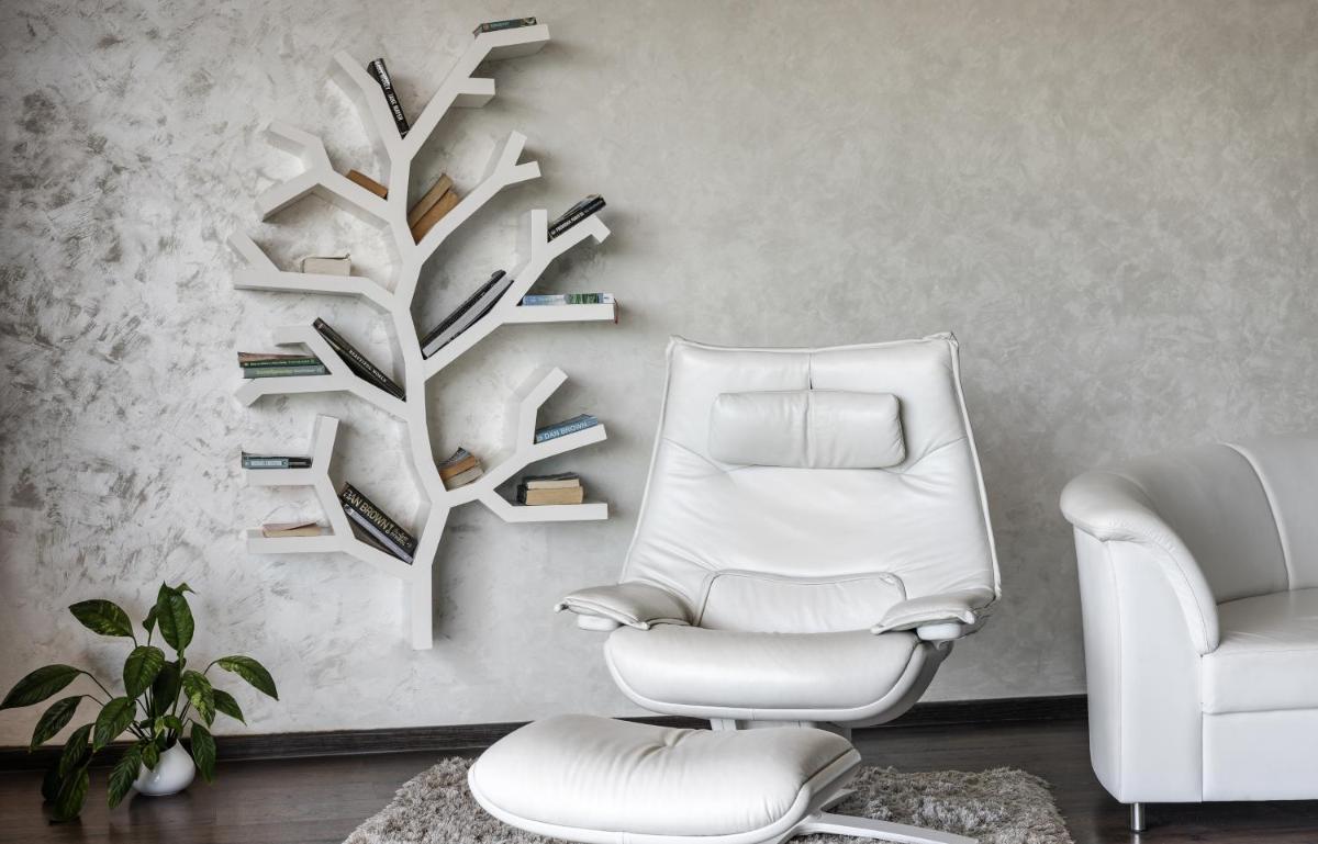 a living room with a chair and a tree shelf at The Panoramic Getaway in Munnar