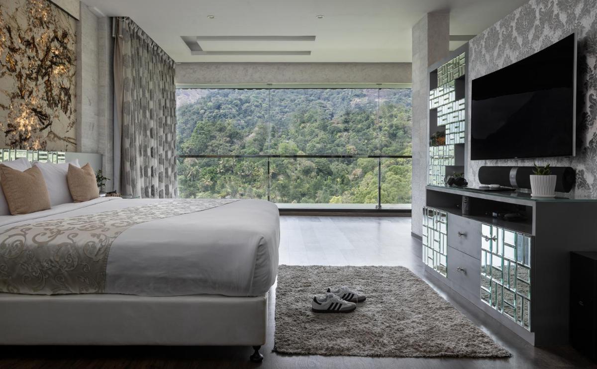 a bedroom with a large bed and a large window at The Panoramic Getaway in Munnar