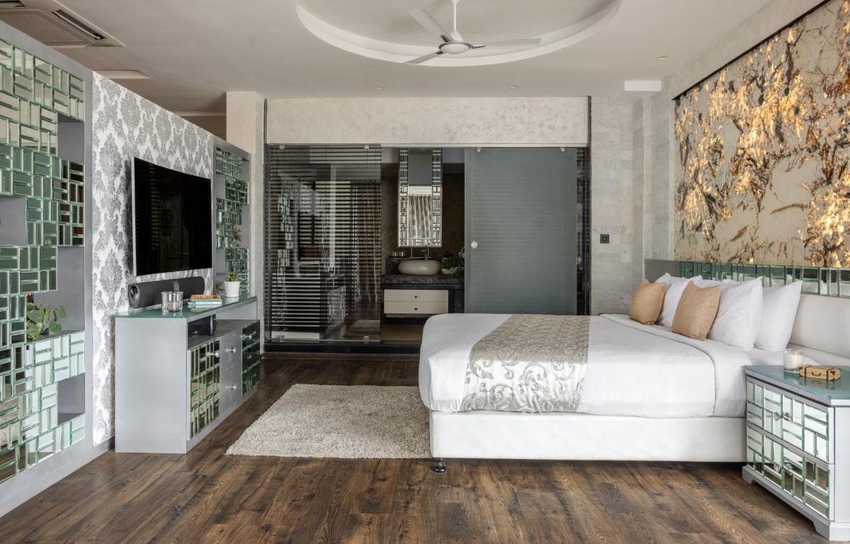 a bedroom with a large bed and a television at The Panoramic Getaway in Munnar