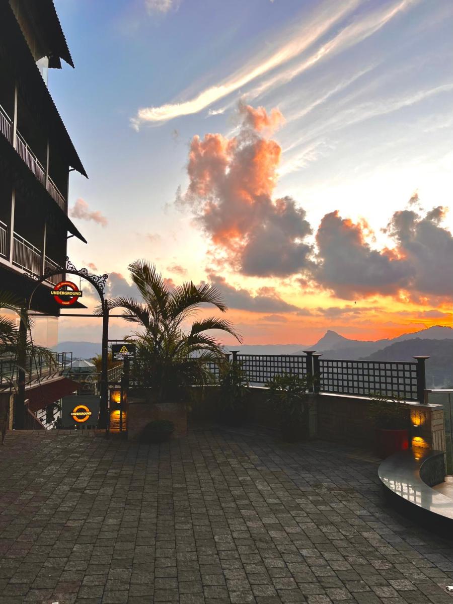 a sunset from a building with a view of the ocean at The Panoramic Getaway in Munnar