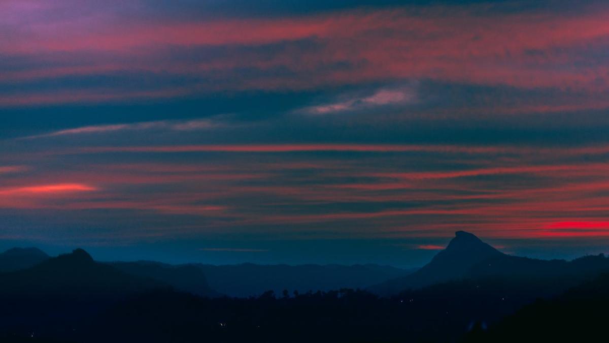 a red and blue sky with mountains in the background at The Panoramic Getaway in Munnar