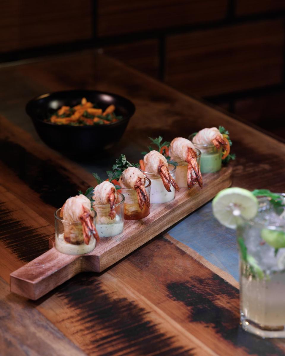 a plate of food on a wooden tray with shrimp at The Panoramic Getaway in Munnar
