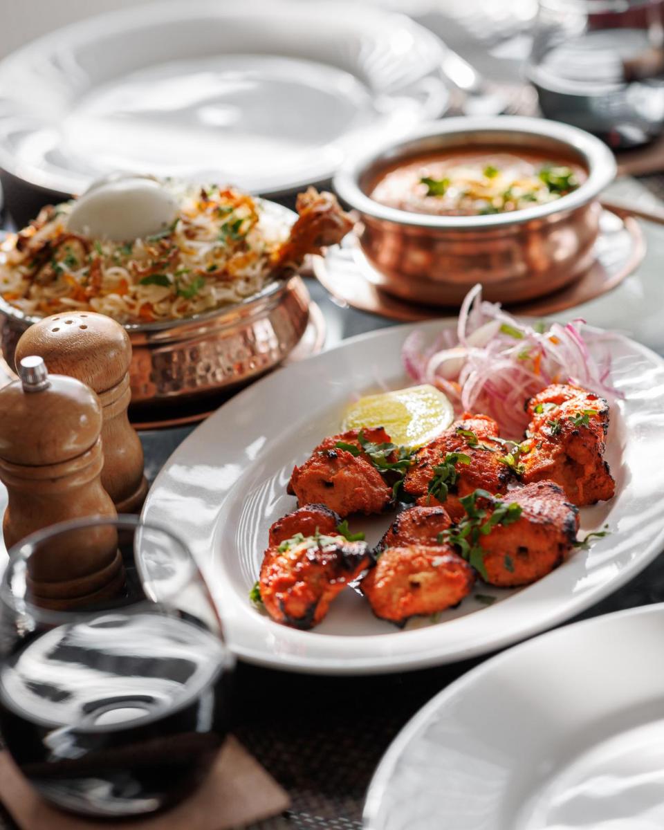 a plate of food on a table with plates of food at The Panoramic Getaway in Munnar